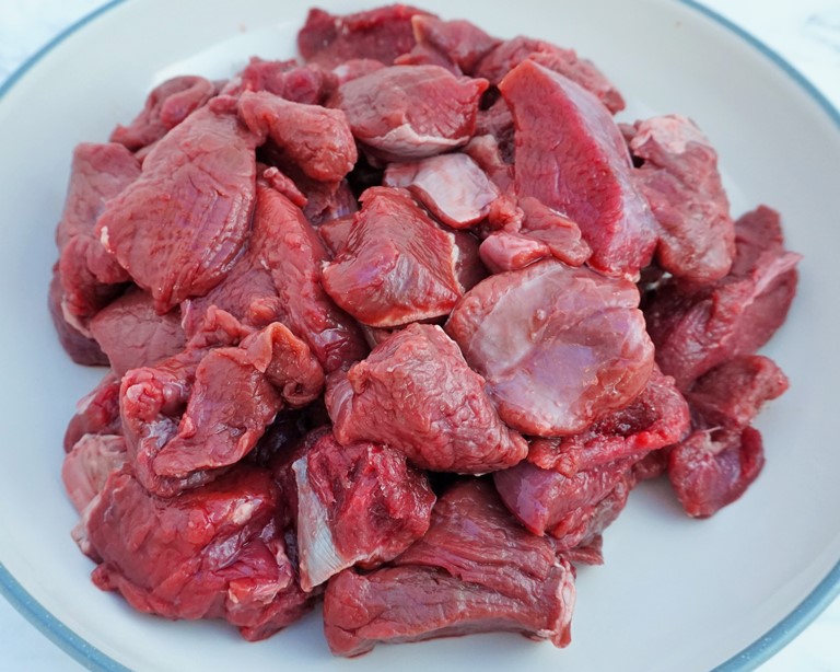 a bowl of raw venison chunks for venison stew recipe