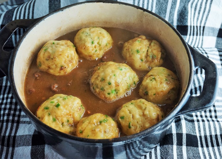casserole dish with venison stew and dumplings