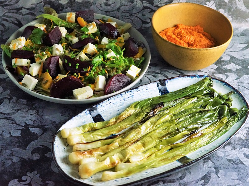 grilled spring onions and romesco sauce served with a salad