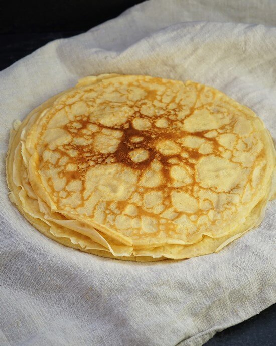 a stack of Traditional English Pancakes on a tea towel