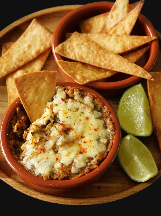 Refried Beans or frijoles refritos with melted cheese and tortilla chips