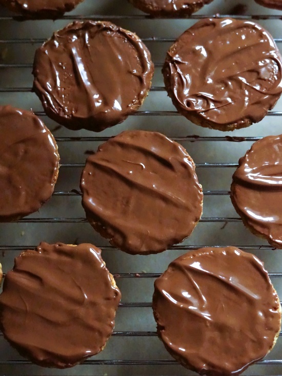 adding chocolate topping to homemade chocolate hobnobs adding chocolate topping to homemade chocolate hobnobs