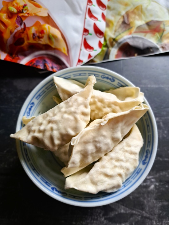packets and a bowl of frozen gyoza dumplings